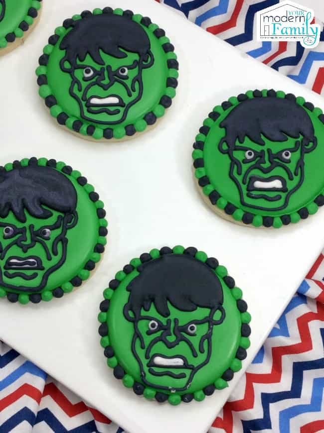 Green iced cookies with the Hulk\'s head in the center of each cookie.