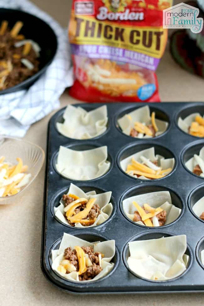 A cupcake pan with Taco Casserole ingredients in each divided section.