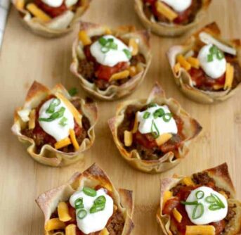 A plate filled with Taco and Cheese cups for a football party.