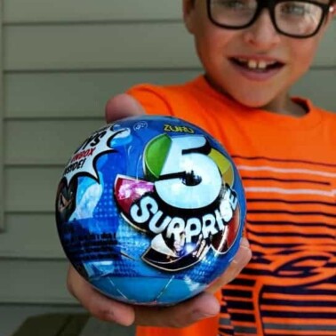 A young boy holding a new toy ball.