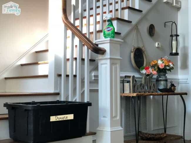 A black plastic container sitting on the bottom step of a staircase.