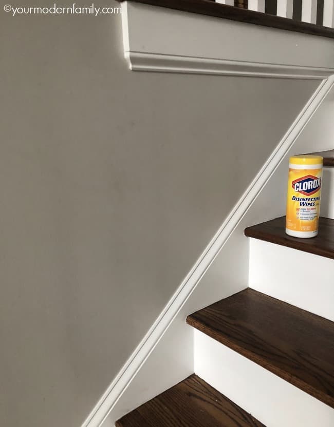 A container of Clorox wipes sitting on wooden stairs.