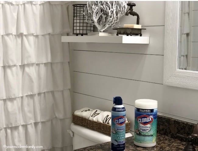 A spray foam bottle  and container of Clorox wipes sitting on the bathroom counter.