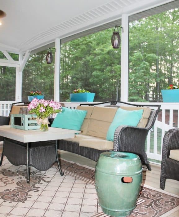 A screened in porch filled with furniture and decorations.