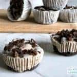 Numerous Cocoa Tortoni cups on a wooden board.