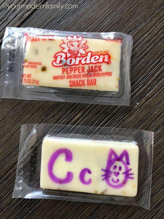 A wrapper Borden cheesy snack with letters and picture drawn on it.