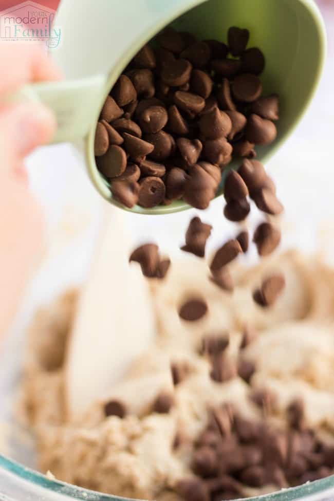 Chocolate chips pouring from a measuring cup.