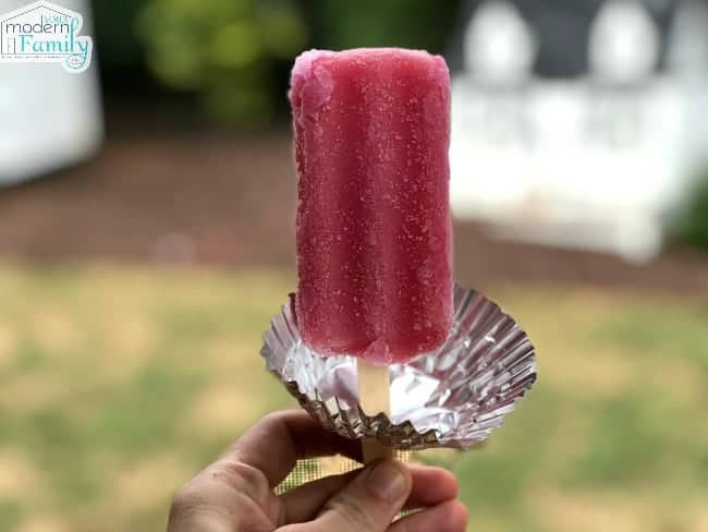 A popcicle with a cupcake liner attached to the popcicle stick.