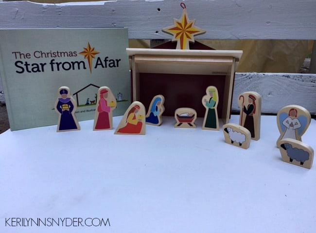 A Christmas manger scene made of wooden people sitting on cotton fluff.