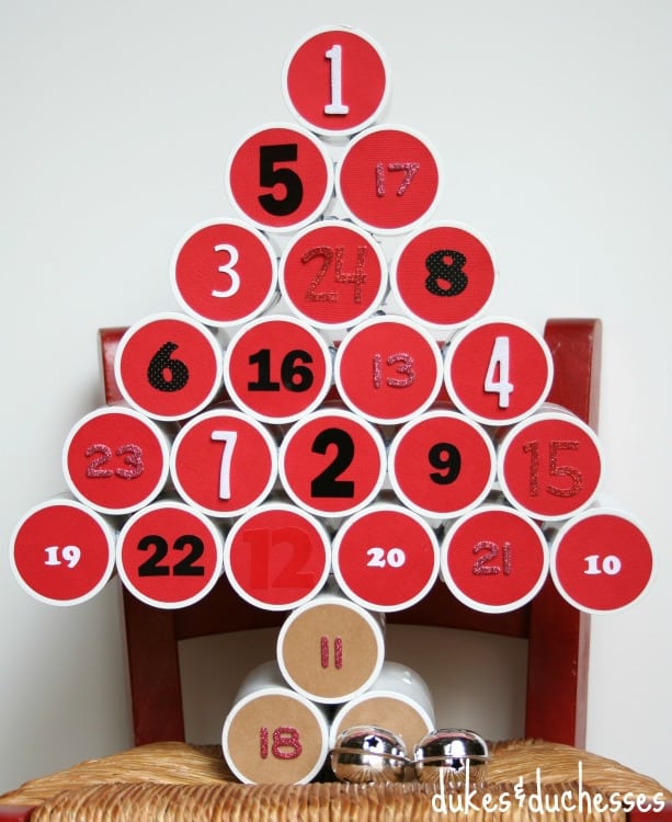 A Christmas tree craft with red circles that make the shape of the tree with numbers on them.