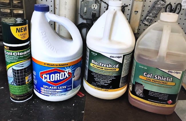 A variety of cleaning products sitting on a counter.
