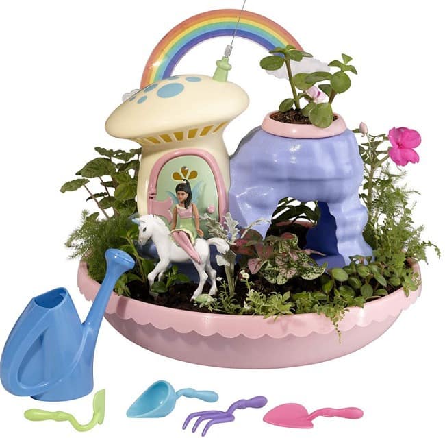 A child\'s garden set in a plastic bowl with garden tools and decorations on a table