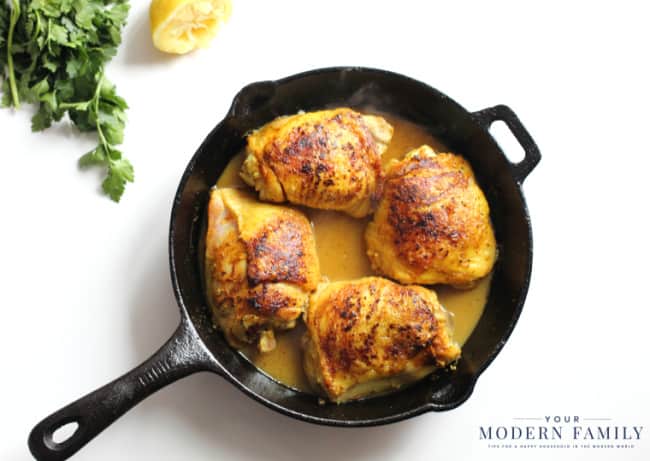 A black skillet with cooked Chicken and Turmeric.