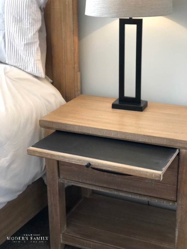 A wooden table with a pullout shelf.