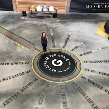 A lady standing on a floor with words on the floor.
