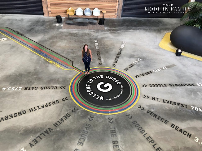 A lady standing on a floor with words on the floor.