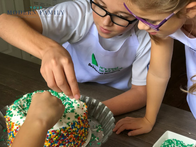 A boy and girl decorating a cake.