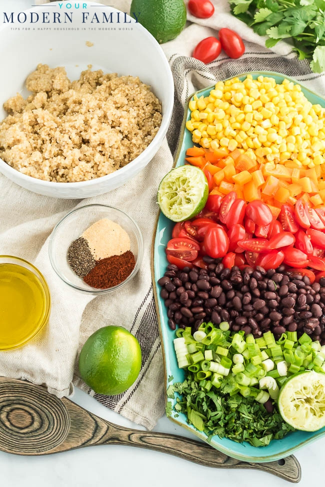 A bowl filled with different types of food on a table, with Quinoa and Salad