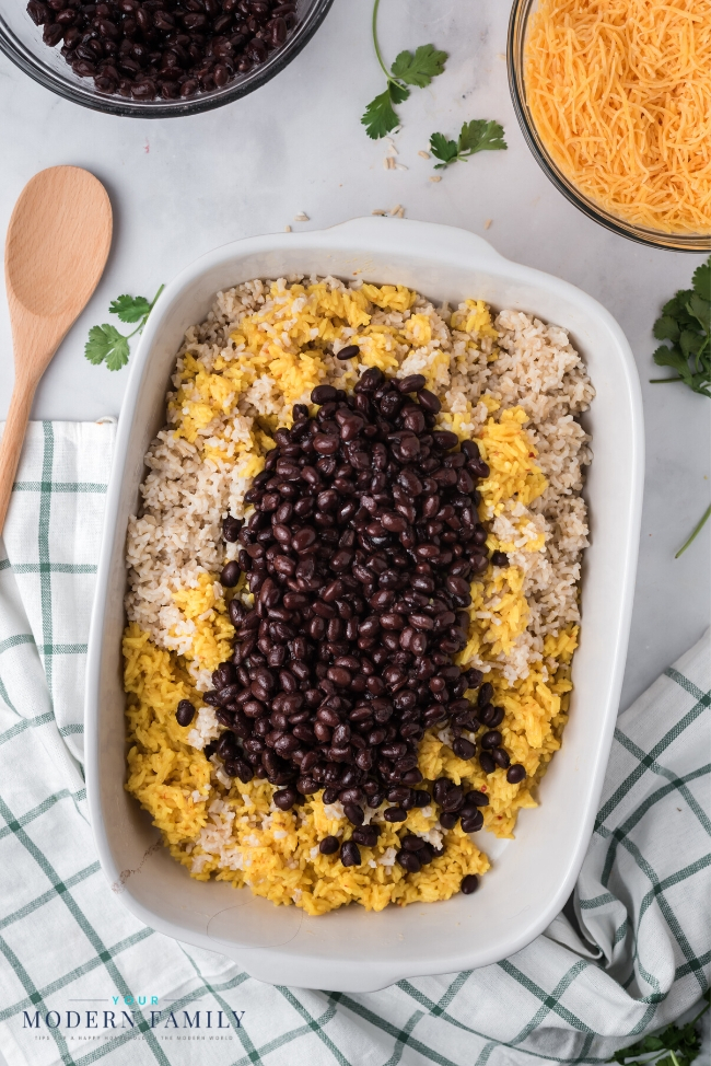 A bowl of food on a plate, with Bean and Yellow rice